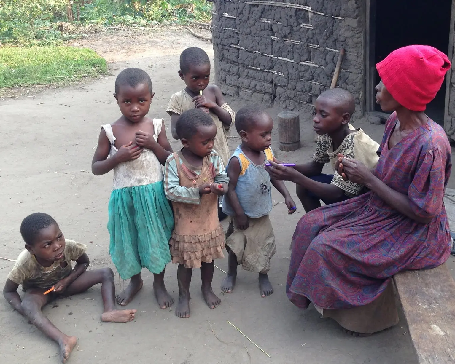 Villagers gathered outside a mud-walled home in Uganda